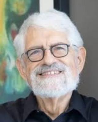 smiling man with white hair, beard, and glasses