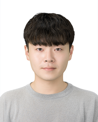 Headshot of man with dark hair in a gray shirt