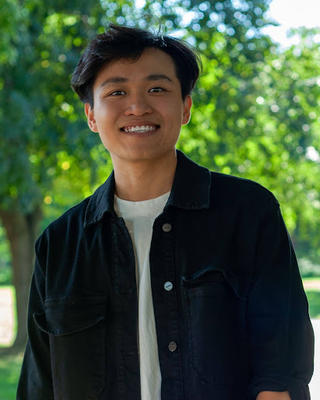man smiling with trees in the background