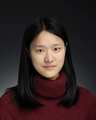 headshot of woman with dark hair in red sweater